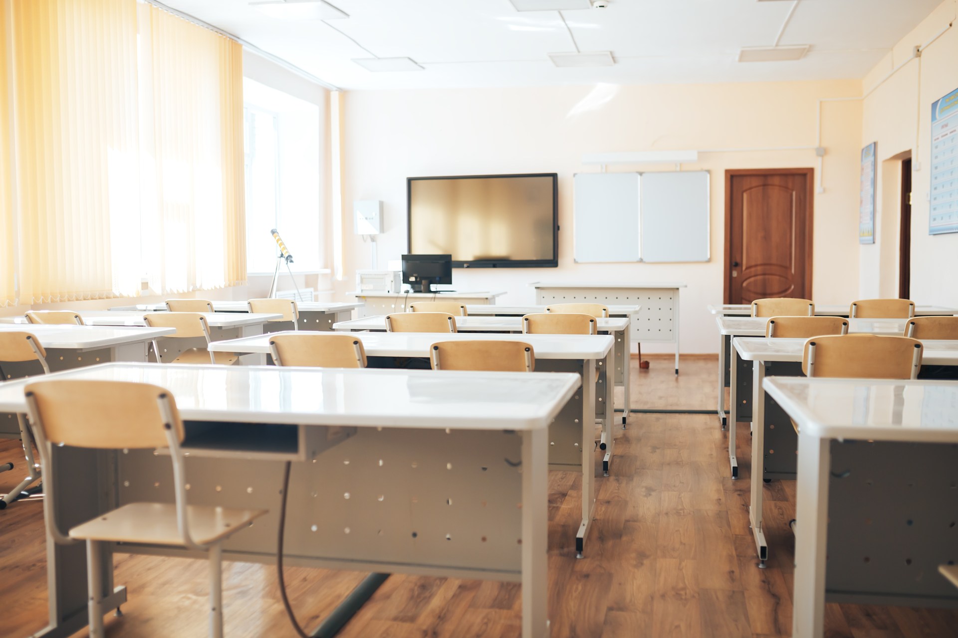 Empty classroom with desks and chairs and whiteboard