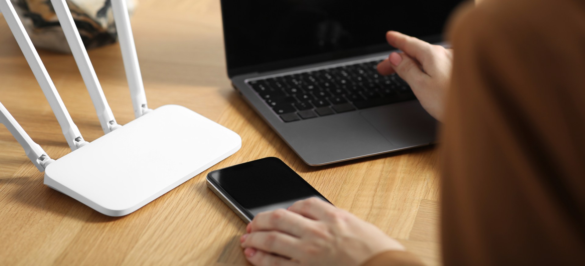 person working on wireless router and laptop on desk