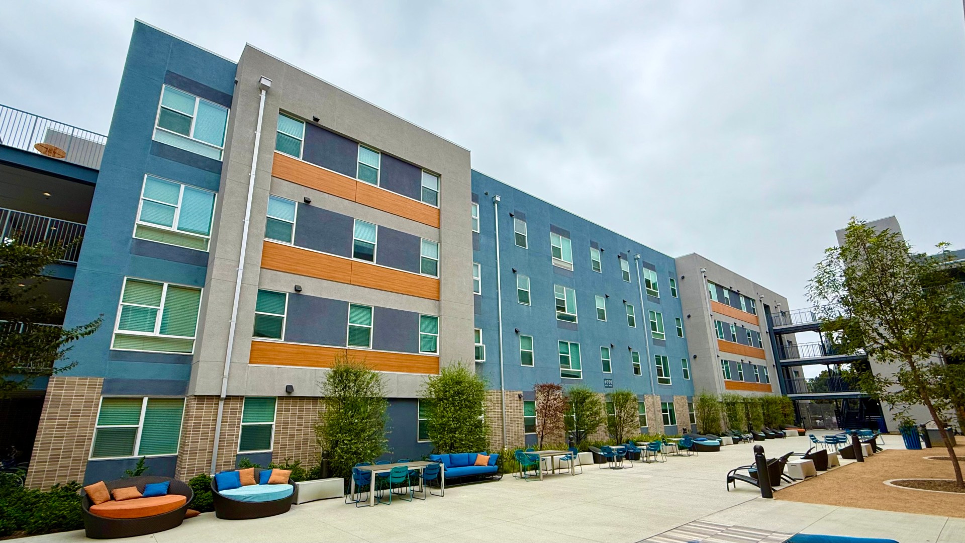 Multi-colored student housing buildings with patio lounge furniture